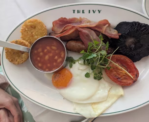 Full English breakfast on an oval restaurant plate, photographed from above on the table where it was served