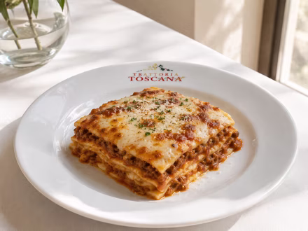 Lasagna on a branded restaurant plate in window light — shot on site by a Splento creator