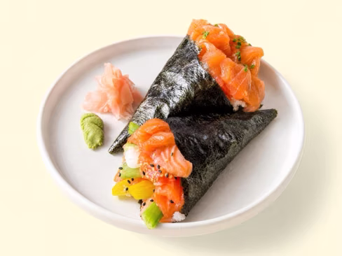 Two salmon hand rolls on a white plate with pickled ginger and wasabi, uploaded by a merchant and edited by Splento